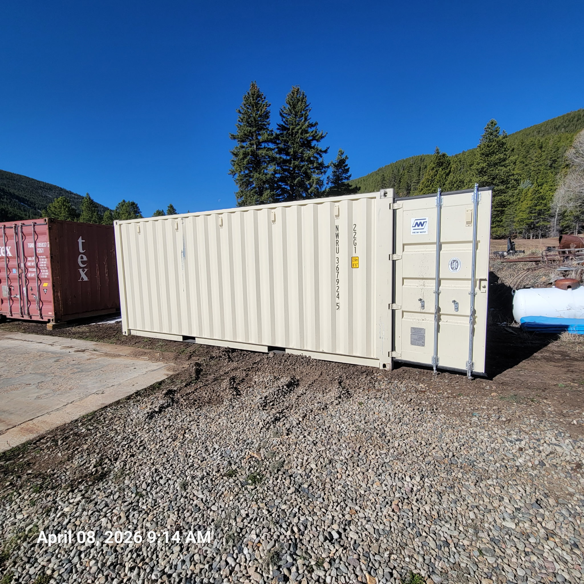 20 ft standard One-Trip container, cream factory paint, side and door end visible, unit ID NWRU367924 and ISO code 22G1, gravel and dirt site