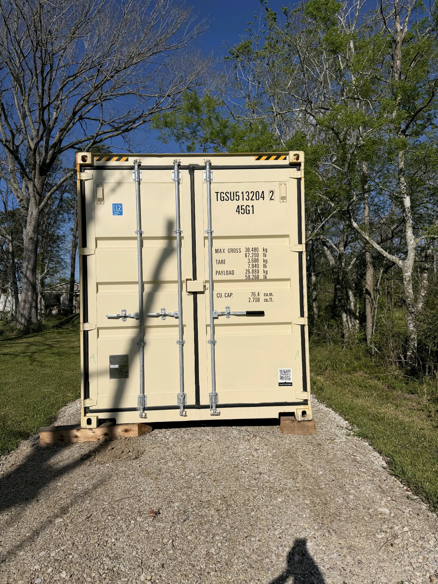 40 ft High-Cube One-Trip container, cream factory paint, door end showing unit ID TGSU513204 and ISO code 45G1, gravel pad placement