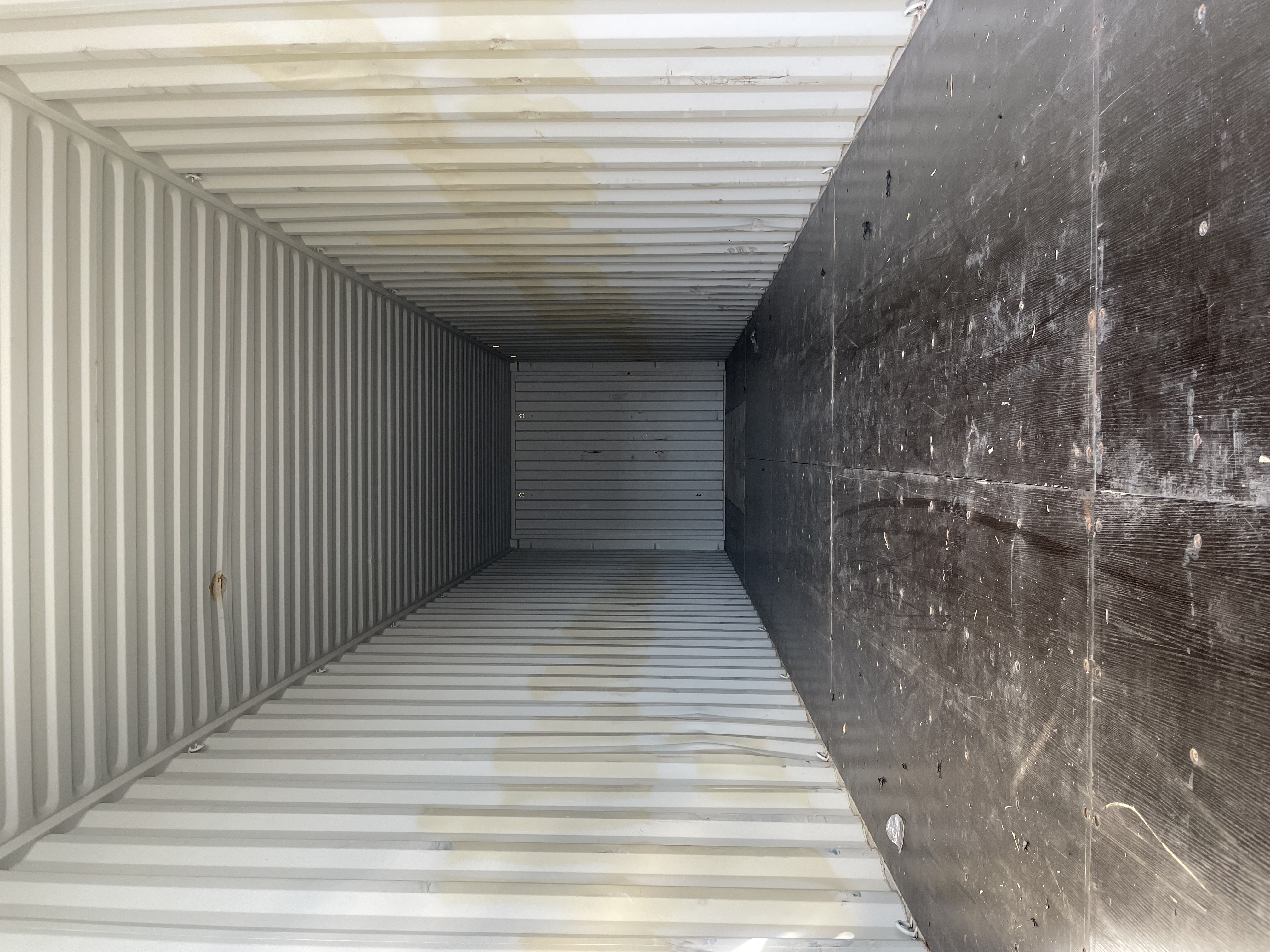 Interior of a white 40 ft High-Cube Premium Multi-Trip container with intact corrugated walls and dark plywood floor