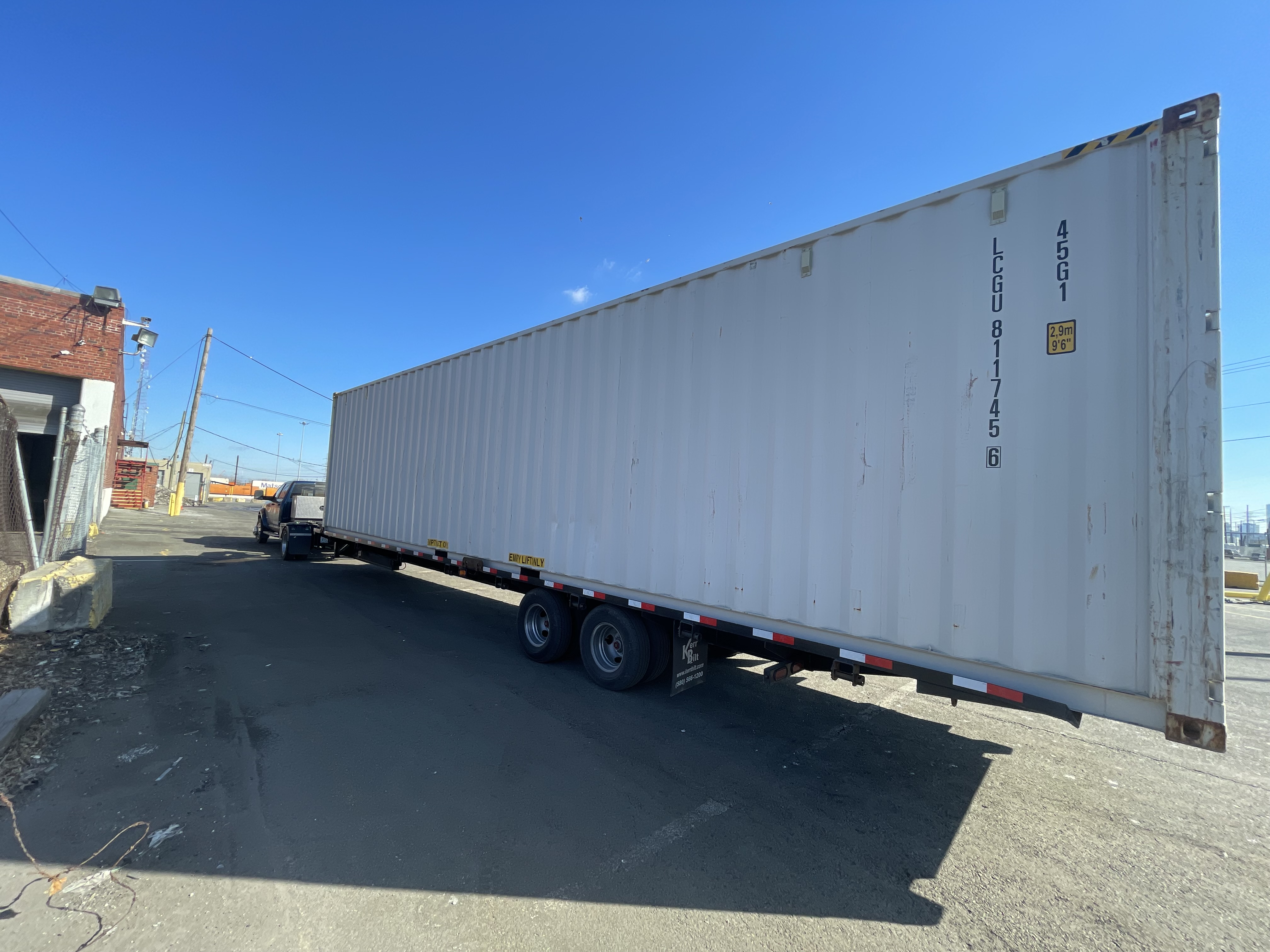 White 40 ft High-Cube Premium Multi-Trip shipping container on a trailer, full side profile