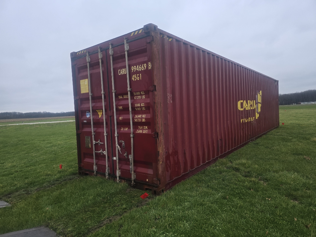 40 ft High-Cube WWT shipping container, CARU Containers livery, dark red paint, delivered to open field