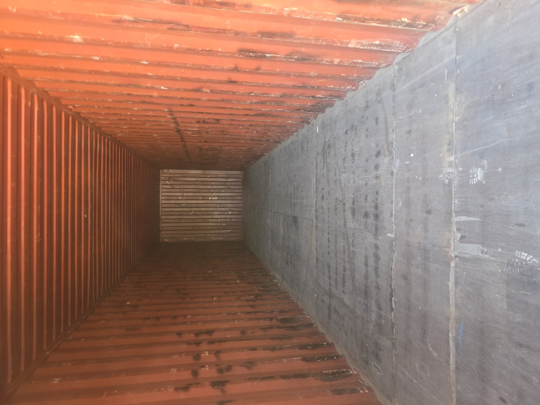 Interior of a 40 ft High-Cube WWT shipping container, looking toward the front wall, corrugated steel walls, steel floor panels, no visible damage