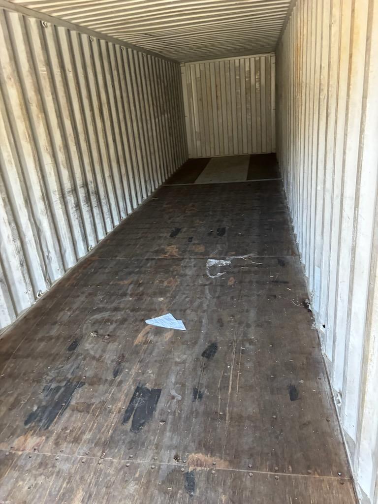 Interior of a 40 ft standard Cargo Worthy container, looking toward front wall, marine-grade plywood flooring showing wear consistent with CW grade